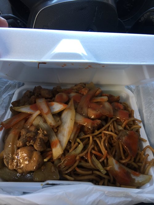 Lo mein noodles with chicken and onions in a takeout container