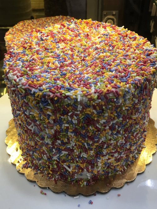 Tall cake covered in rainbow sprinkles