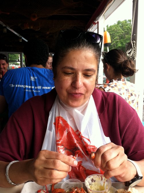 Woman in a lobster bib cracking a lobster