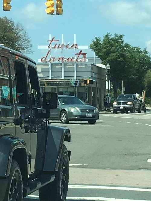 Twin Donuts sign at a city intersection