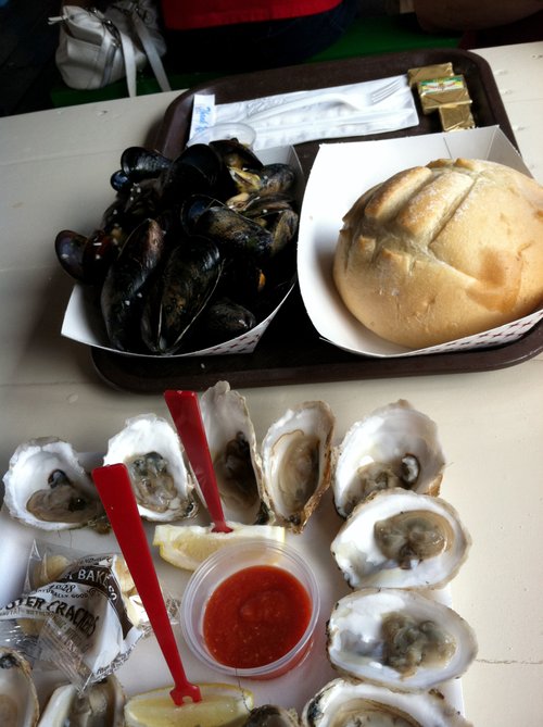 Steamed mussels, bread and raw oysters on a tray