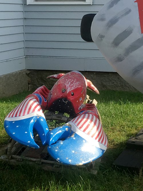 Lobster statue painted in stars and stripes on the lawn at Woodman's