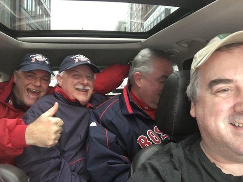 Selfie with three smiling Red Sox fans in the back seat