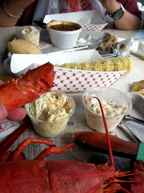Lobster dinner with corn, potato salad and coleslaw