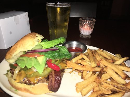 Burger with fries and a beer on a restaurant table