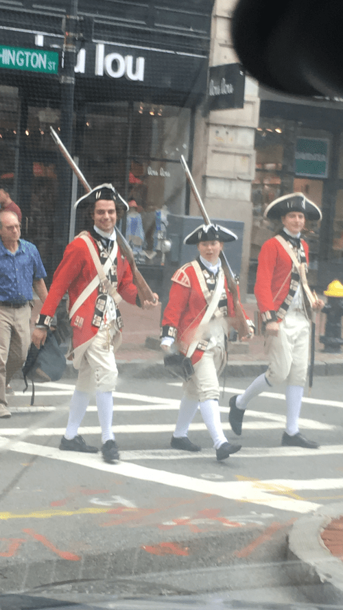 Men in Revolutionary War redcoat uniforms crossing a Boston street