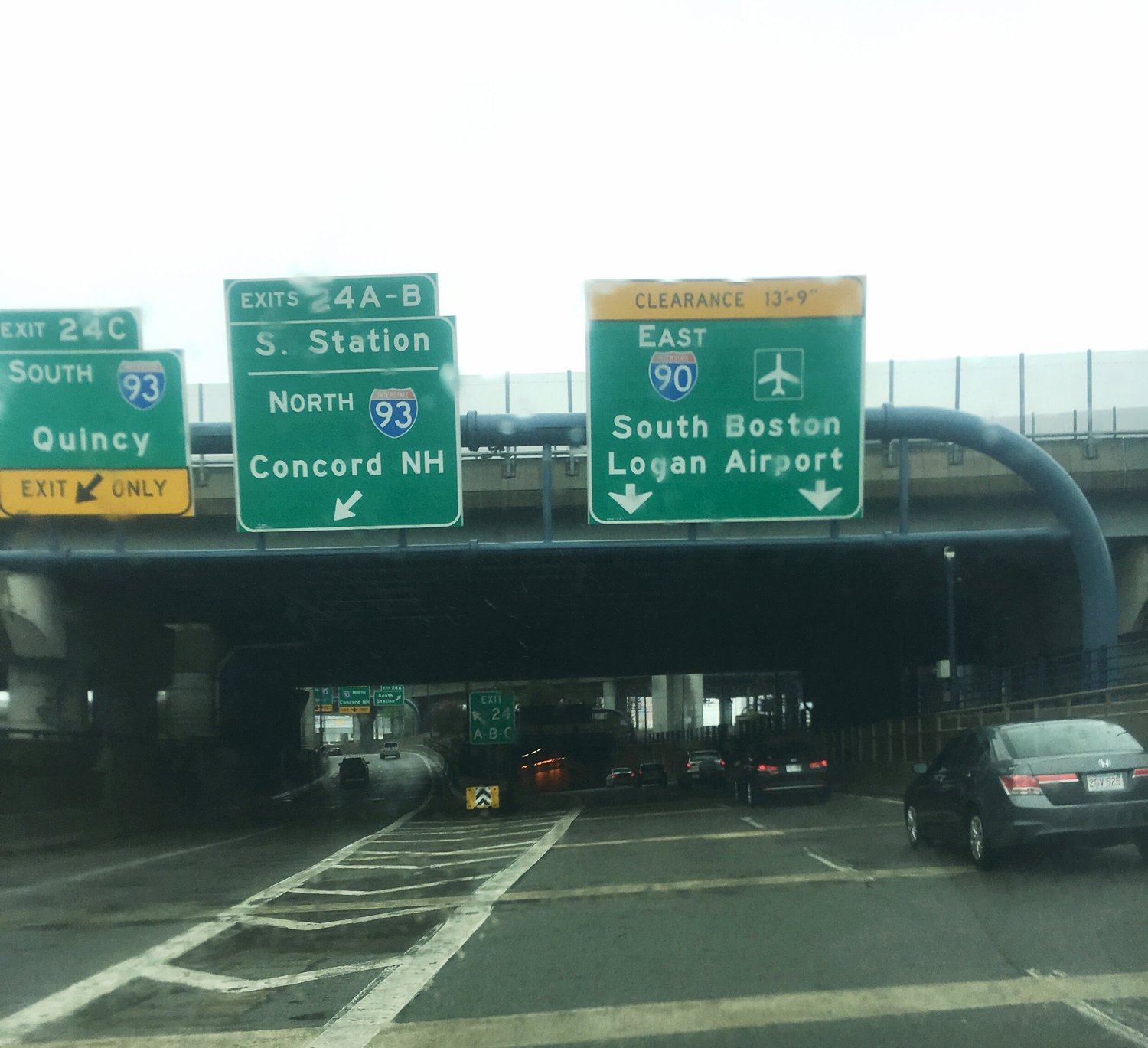 Overhead signs for I-93 North and South and I-90 East to the airport