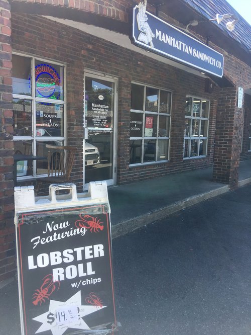 Manhattan Sandwich Co. storefront with a "Now featuring lobster roll" sign