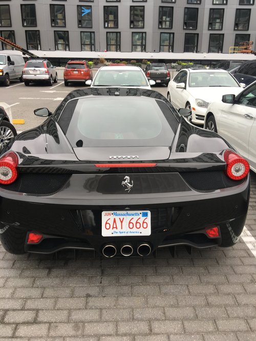 Black Ferrari with a Massachusetts plate in a parking lot