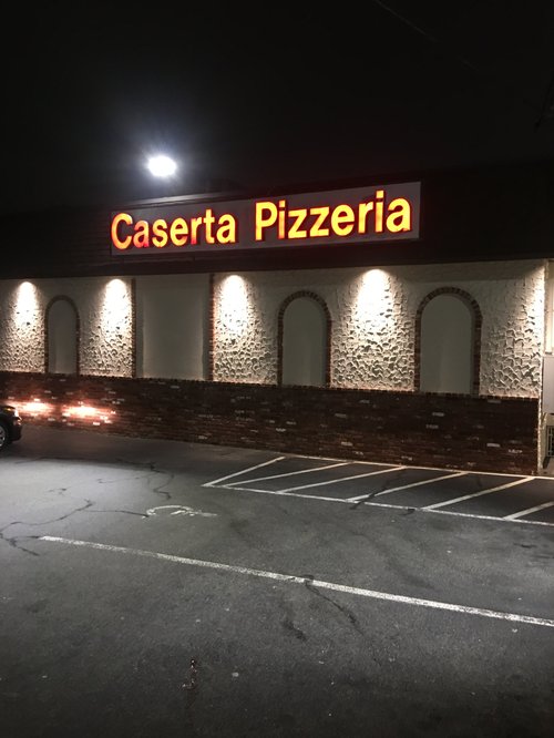 Caserta Pizzeria sign lit at night