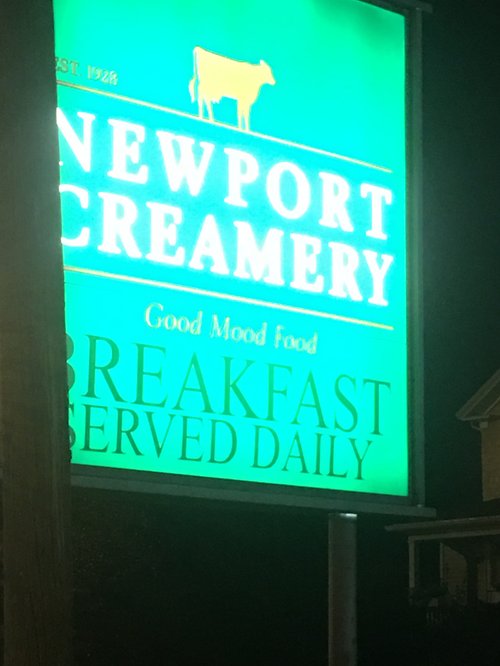 Lit Newport Creamery sign at night: breakfast served daily