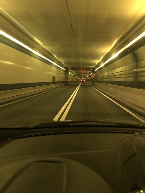 Driving through a lit highway tunnel