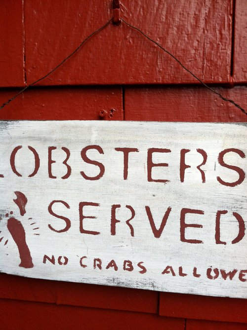 Hand-painted sign: "Lobsters served, no crabs allowed"