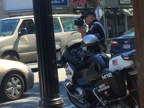 Police motorcycle officer using a radar gun
