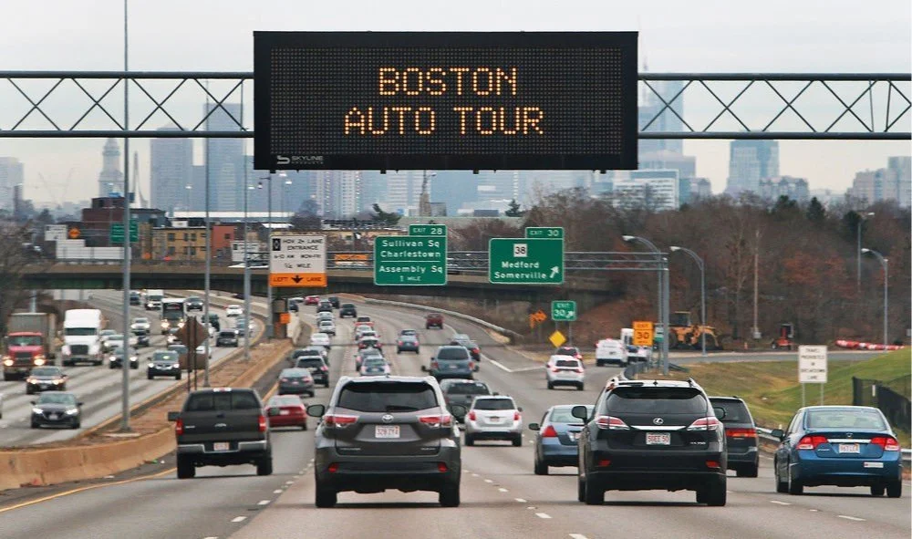 A highway message sign over Boston traffic