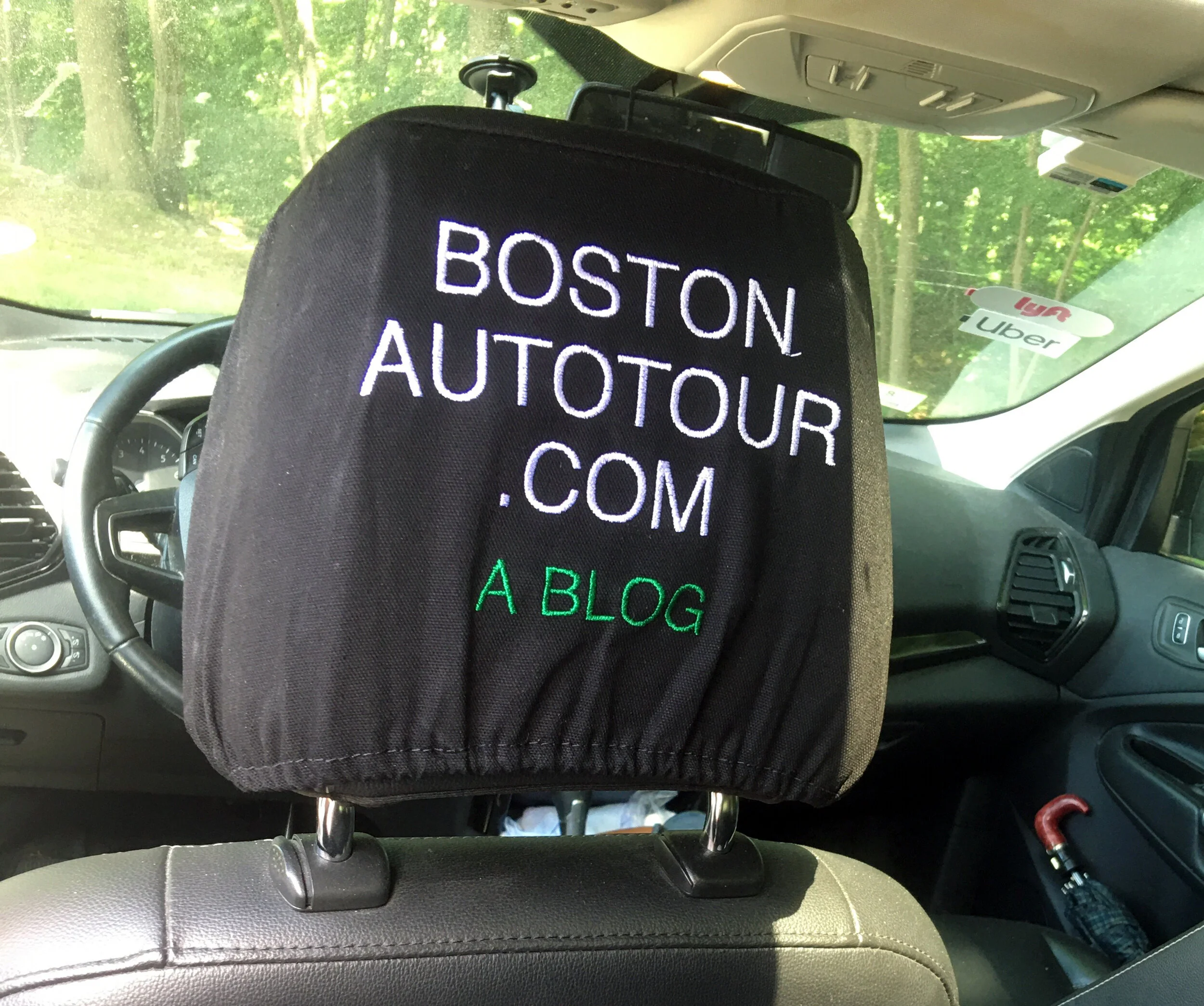 A headrest cover in the car, stitched with the blog name