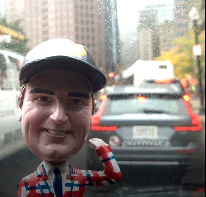 A bobblehead of Jim on the dashboard