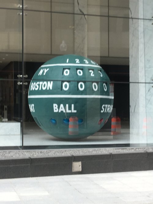 Giant green ball painted like the Fenway scoreboard in a lobby window