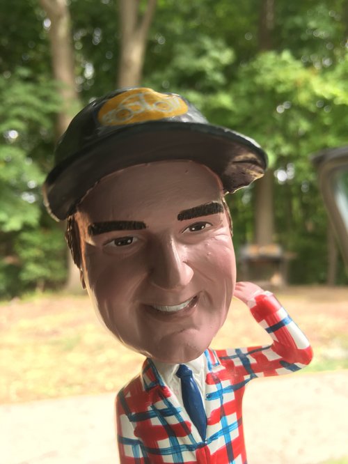 Bobblehead of Jim in a plaid jacket and cap