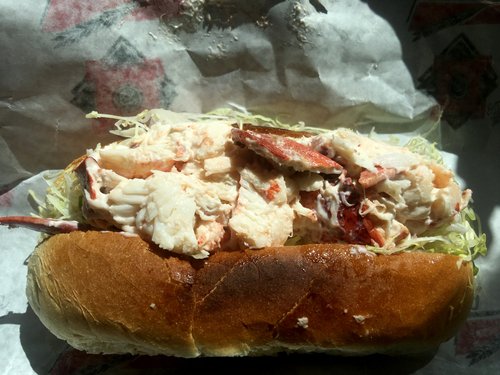 Lobster roll piled with lobster meat on shredded lettuce