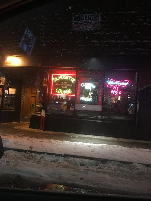 Silhouette Lounge with neon beer signs at night