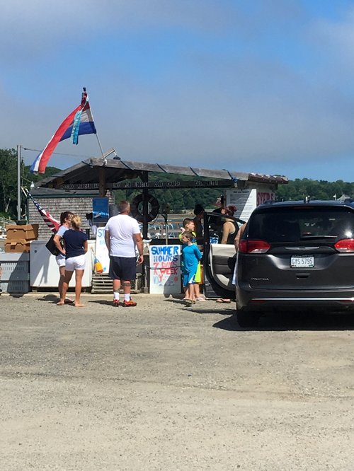 Customers at a roadside lobster stand by the water