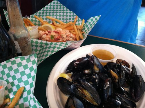 Mussels, lobster roll and fries on a restaurant table