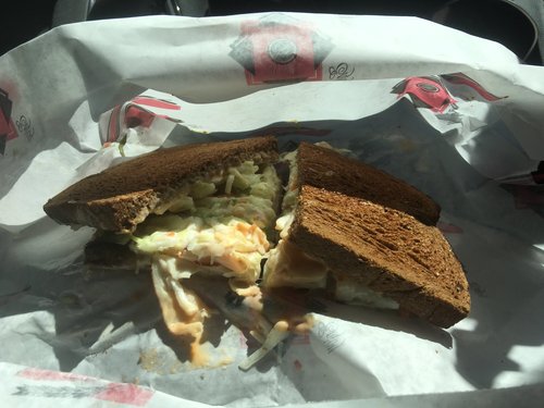 Reuben sandwich on dark rye in deli paper
