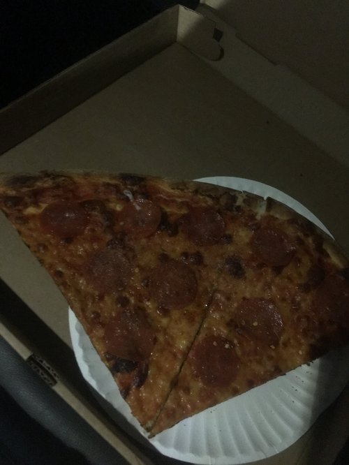 Slice of pepperoni pizza on a paper plate