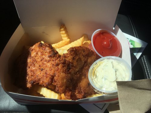 Fried fish and fries in a takeout box