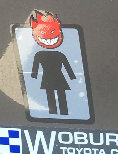 Bumper sticker of a woman figure with a flaming devil head