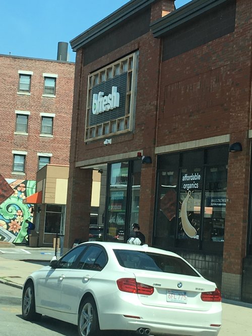 b.fresh market storefront with a white car outside