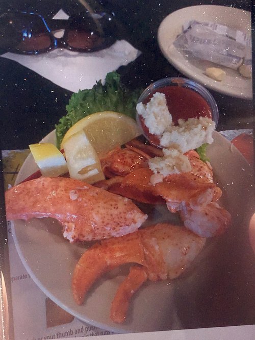 Lobster claws and tail meat on a plate with lemon and butter