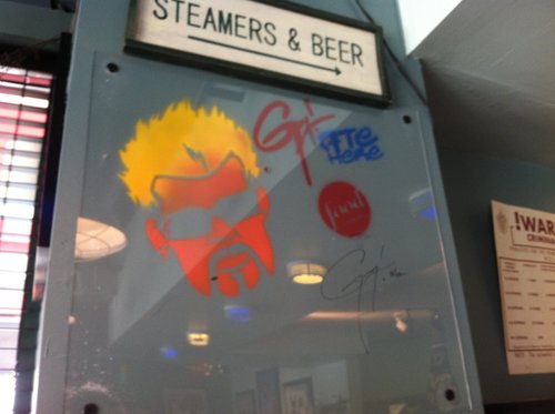 Guy Fieri caricature on a "Steamers & Beer" sign