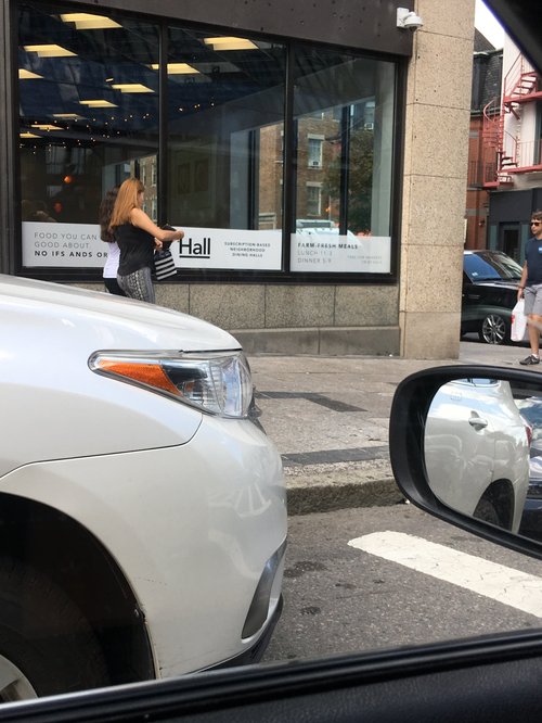 Restaurant storefront seen from a car on a city street